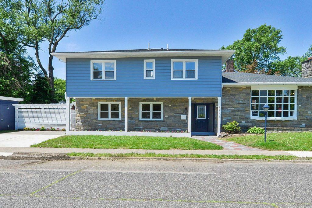 Ouside of a blue, two story house designed by Goldleaf Designs